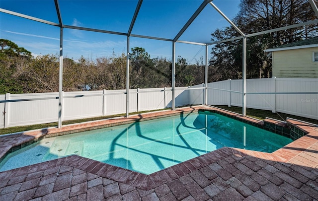 view of swimming pool with glass enclosure and a patio area