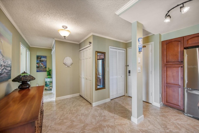 entryway with crown molding and a textured ceiling