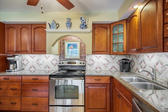 kitchen featuring appliances with stainless steel finishes, decorative backsplash, sink, ceiling fan, and light stone counters