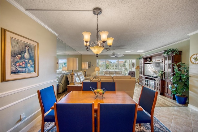 tiled dining area featuring crown molding, ceiling fan with notable chandelier, and a textured ceiling