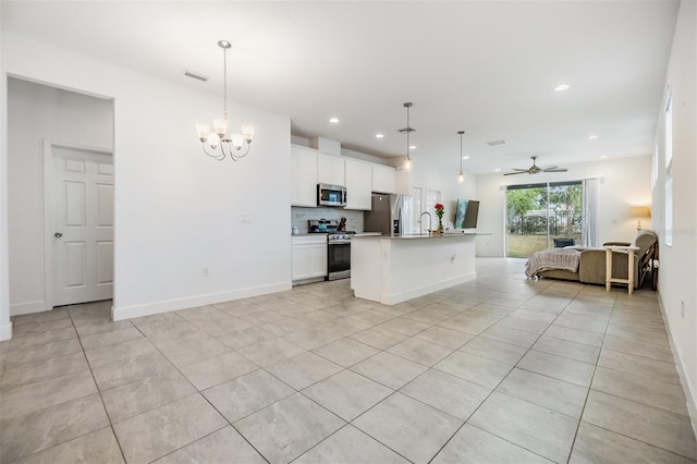 kitchen with decorative light fixtures, backsplash, a center island with sink, and stainless steel appliances