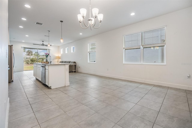 kitchen with sink, hanging light fixtures, appliances with stainless steel finishes, and an island with sink