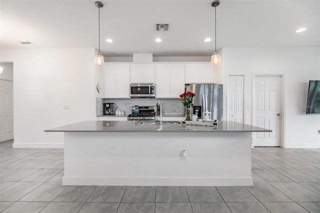 kitchen featuring sink, hanging light fixtures, a center island with sink, and appliances with stainless steel finishes