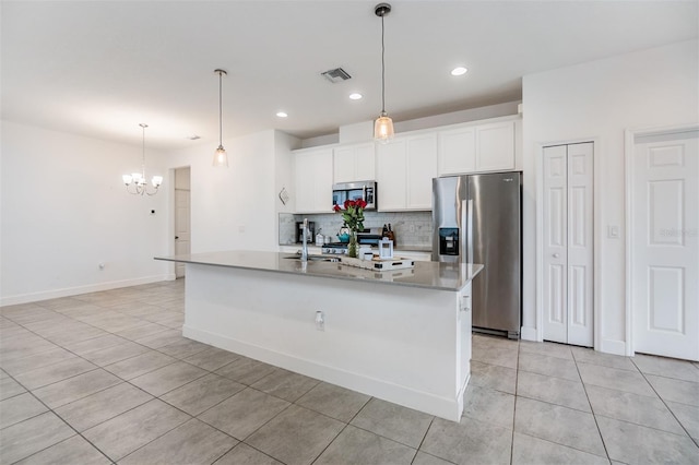 kitchen featuring decorative light fixtures, white cabinetry, stainless steel appliances, tasteful backsplash, and a kitchen island with sink