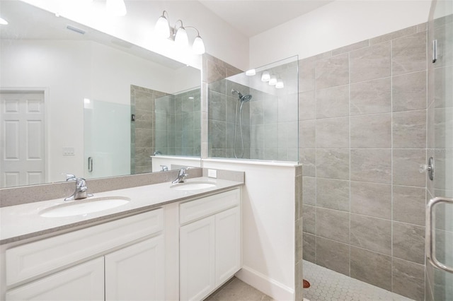 bathroom featuring a shower with door and vanity