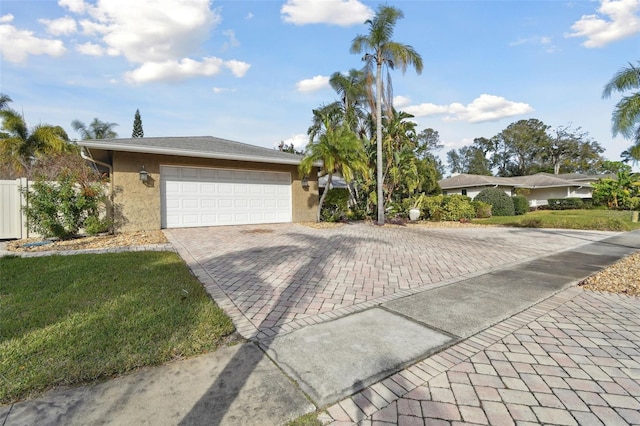 single story home with a garage and a front lawn