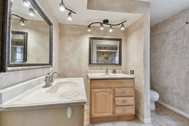 bathroom featuring toilet, tile patterned flooring, and vanity