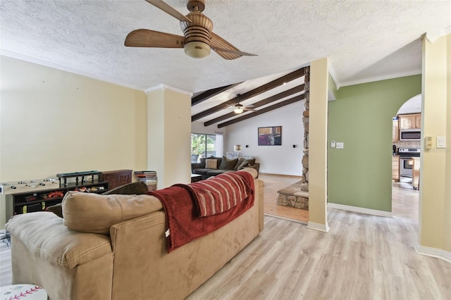 living room with ceiling fan, a textured ceiling, lofted ceiling with beams, and light wood-type flooring