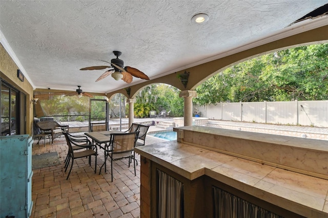 view of patio / terrace with a fenced in pool, ceiling fan, and a bar