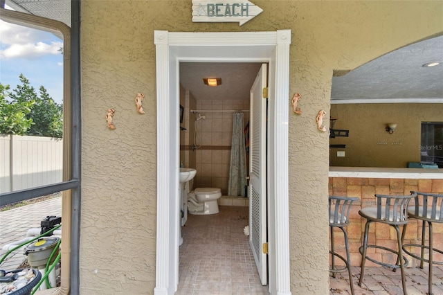 interior space featuring a shower with curtain, toilet, and ornamental molding