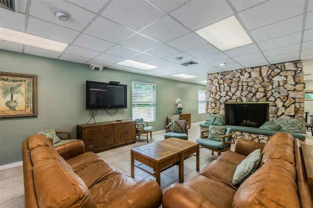 tiled living room with a fireplace and a drop ceiling