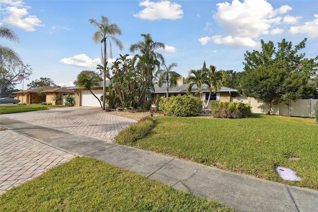 ranch-style house featuring a garage and a front lawn