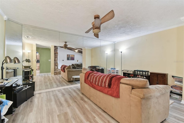 living room featuring ceiling fan, crown molding, and a textured ceiling