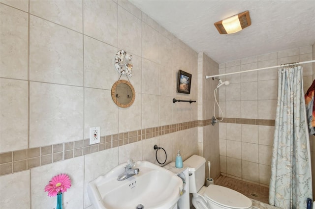 bathroom featuring sink, toilet, tile walls, and a shower with curtain