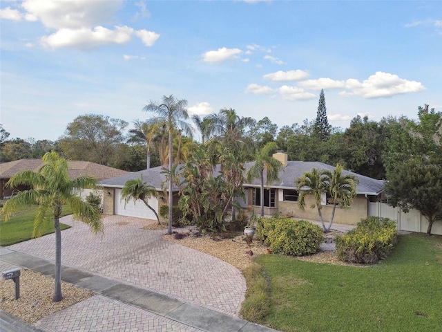 ranch-style home with a garage and a front lawn