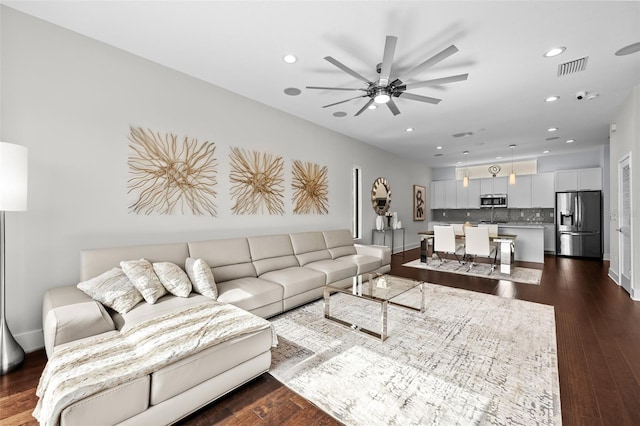 living room featuring ceiling fan and dark hardwood / wood-style flooring