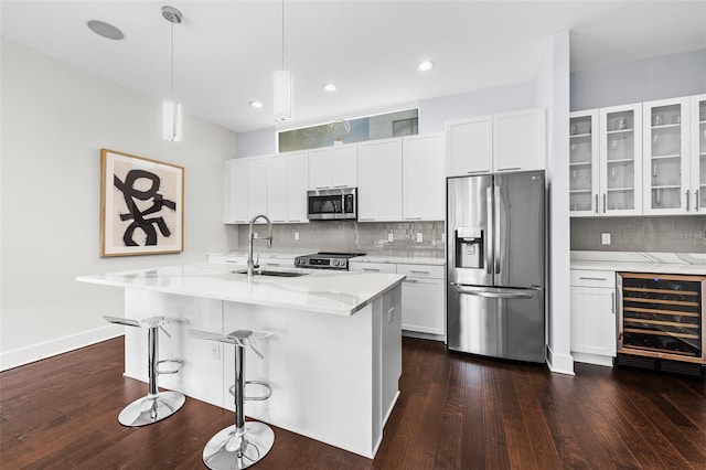 kitchen with white cabinetry, beverage cooler, hanging light fixtures, and stainless steel appliances