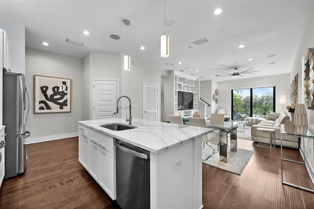 kitchen featuring light stone countertops, appliances with stainless steel finishes, white cabinetry, sink, and a kitchen island with sink