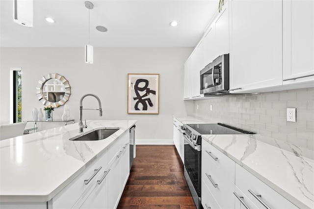 kitchen featuring pendant lighting, appliances with stainless steel finishes, sink, white cabinets, and light stone counters