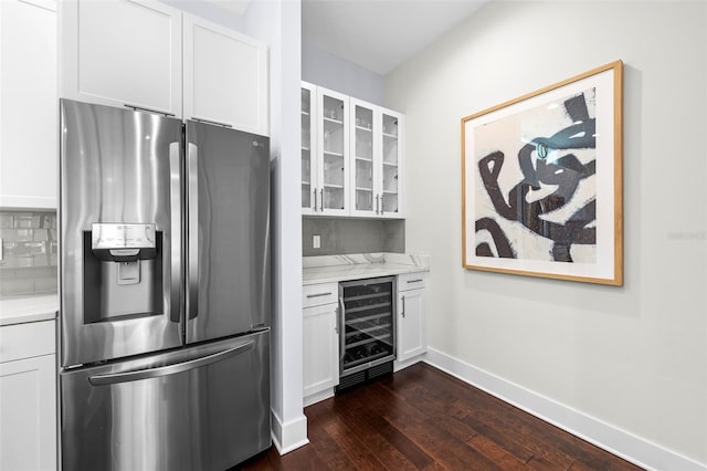 kitchen with stainless steel refrigerator with ice dispenser, light stone countertops, white cabinetry, and beverage cooler