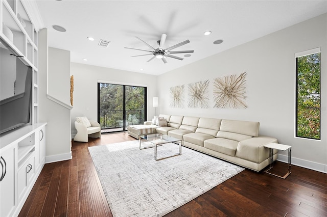 living room featuring ceiling fan and dark wood-type flooring