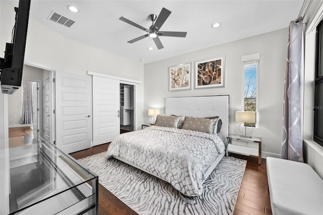 bedroom with dark wood-type flooring, a closet, and ceiling fan