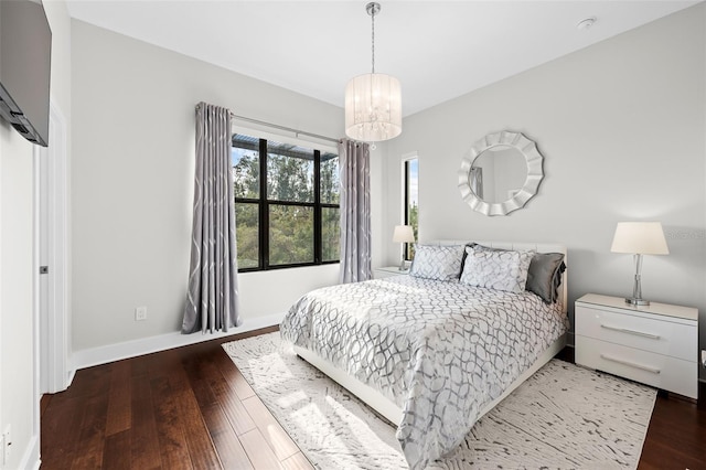 bedroom with a chandelier and dark hardwood / wood-style floors