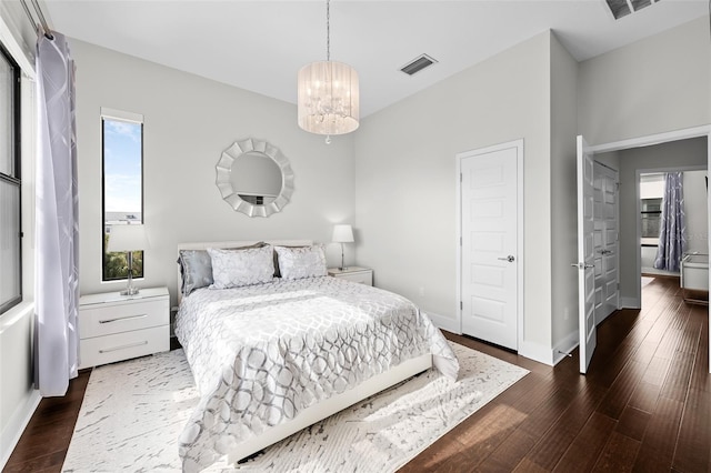 bedroom featuring a notable chandelier and dark hardwood / wood-style flooring