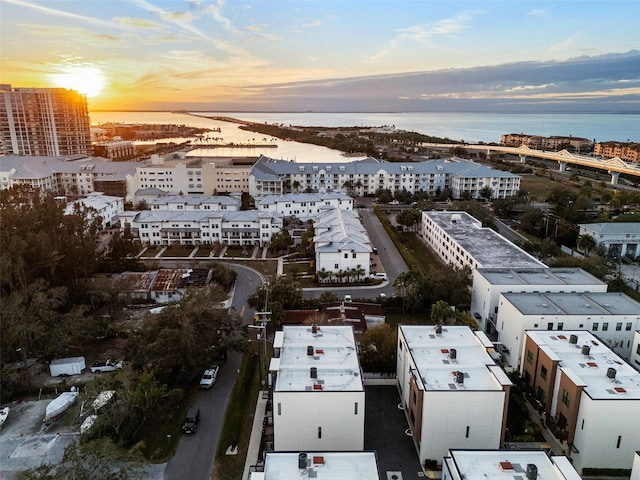 aerial view at dusk featuring a water view