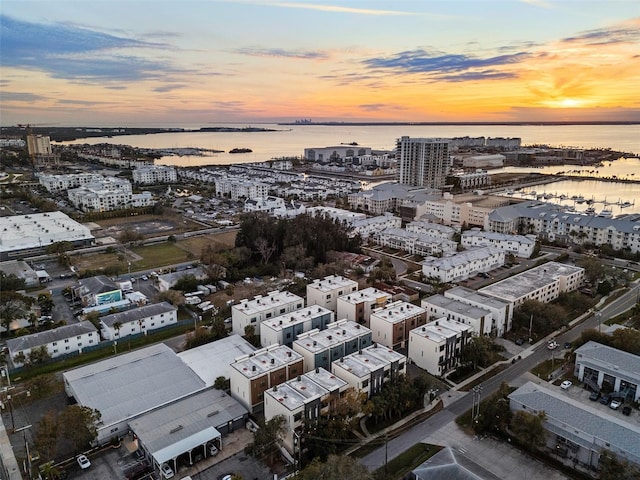 aerial view at dusk featuring a water view