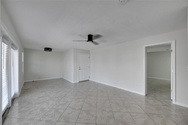 spare room featuring light tile patterned floors and ceiling fan