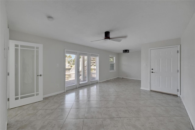 tiled spare room with ceiling fan and french doors