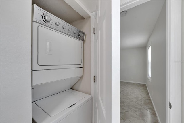 clothes washing area with light tile patterned floors and stacked washer / drying machine