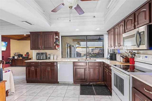 kitchen featuring sink, white appliances, crown molding, and a tray ceiling