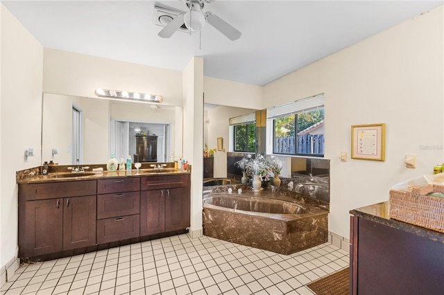 bathroom featuring ceiling fan, a relaxing tiled tub, tile patterned floors, and vanity