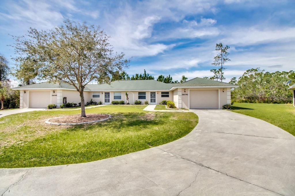 ranch-style house featuring a garage and a front lawn