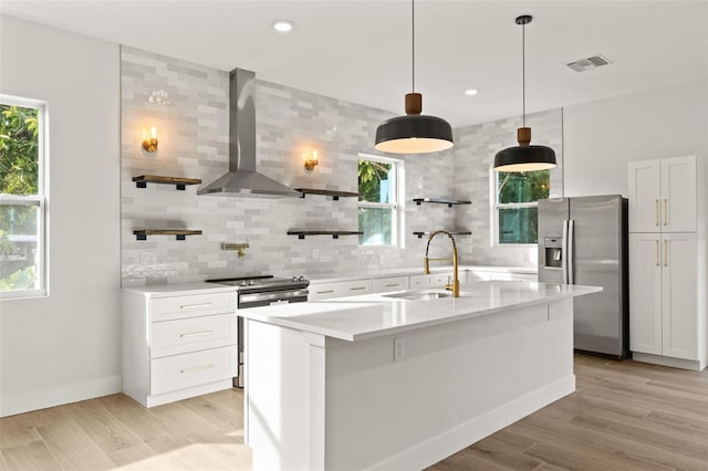 kitchen with sink, white cabinets, wall chimney exhaust hood, and appliances with stainless steel finishes