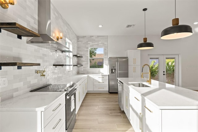 kitchen with light stone countertops, white cabinetry, stainless steel appliances, sink, and hanging light fixtures