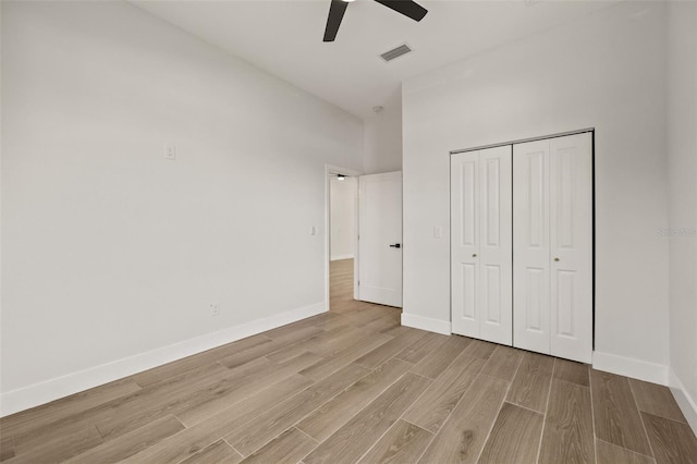 unfurnished bedroom with light hardwood / wood-style floors, a closet, and ceiling fan