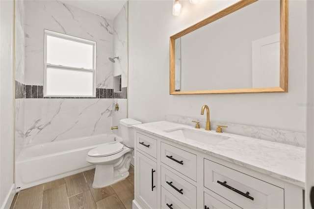 full bathroom featuring toilet, tiled shower / bath, and vanity