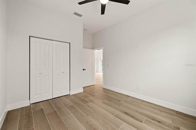 unfurnished bedroom with ceiling fan, a closet, and light wood-type flooring