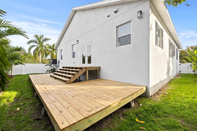 rear view of property featuring a wooden deck and a yard