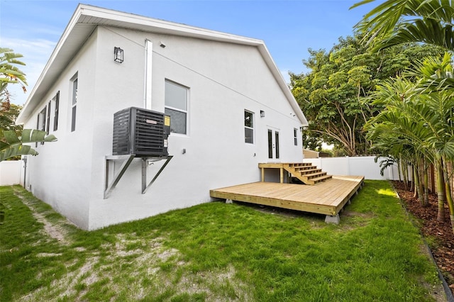 rear view of property with a deck and a lawn