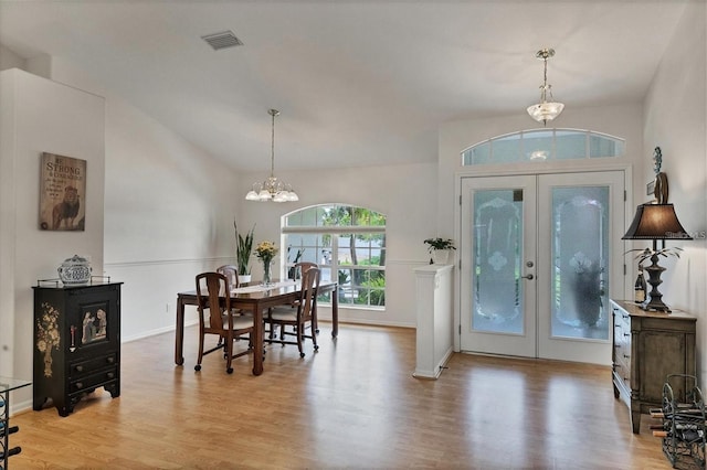 entrance foyer with french doors, a chandelier, and light wood-type flooring