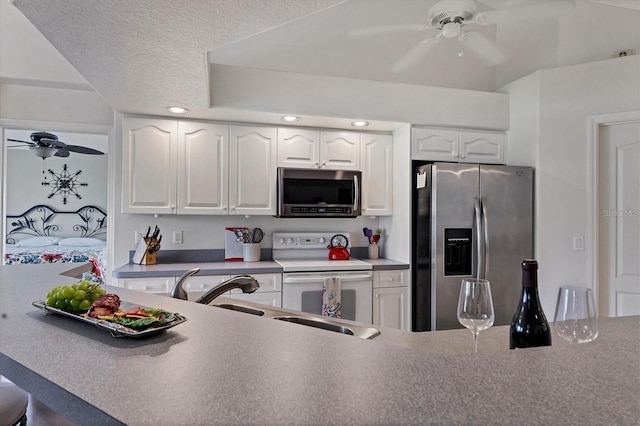 kitchen with sink, ceiling fan, appliances with stainless steel finishes, white cabinetry, and a textured ceiling