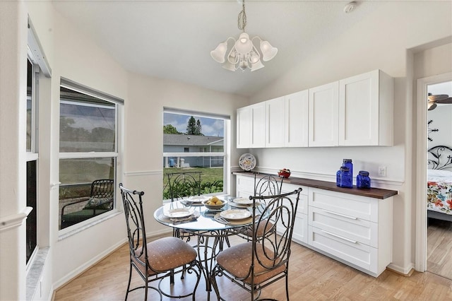 dining area featuring vaulted ceiling, an inviting chandelier, and light wood-type flooring