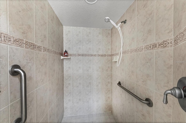 interior details with a textured ceiling and tiled shower