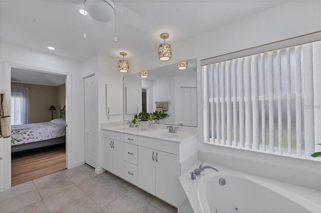 bathroom with tile patterned flooring, vanity, and a tub to relax in