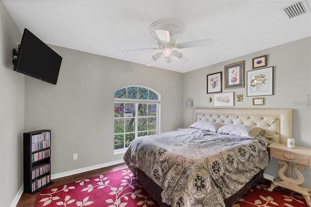 bedroom with dark hardwood / wood-style flooring and ceiling fan