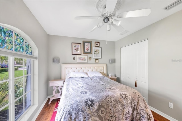 bedroom with ceiling fan, wood-type flooring, and a closet